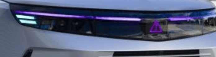 Un punto esclamativo dentro un triangolo è di corredo comunicativo al colore magenta che avvisa il pedone del pericolo imminente per la ripartenza dell'auto a guida autonoma