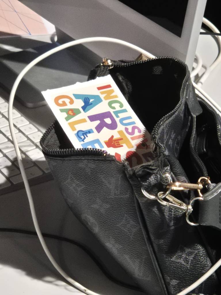 l'adeisvo INCLUSIVE ARTS GALLERY viene messo nella borsetta