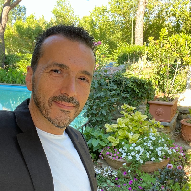 maturo signore elegante con barbetta sorridente nel giardino